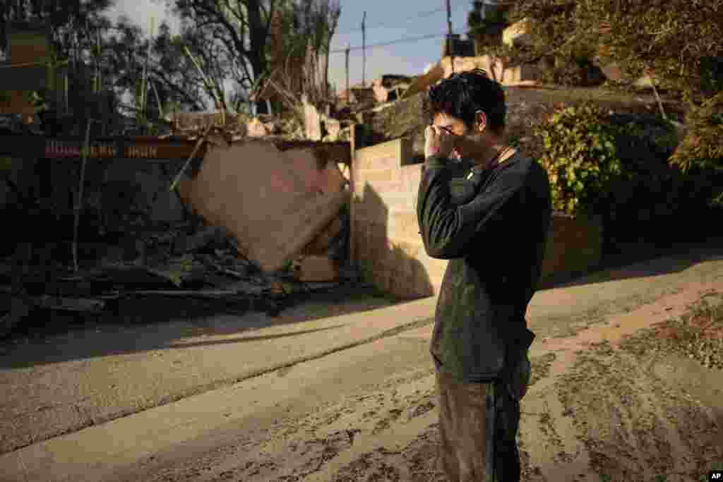 Oliver Braren wipes his eyes as he takes a moment from sifting through Kaegan Baron's mother's home after it was destroyed by the Palisades Fire in the Pacific Palisades neighborhood of Los Angeles, Jan. 11, 2025.