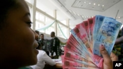 A woman holds Ghana's currency (File)