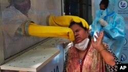 Mushandi wezvehutano achivheneka munhu kuona kana aine covid-19. Nyanzvi mune zvehutano dzinoti veruzhinji havafanirwe kuvarairwa nekuderera kwehuwandu hwevanhu vari kuwanikwa vaine chirwere ichi.