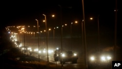 FILE - A convoy of Israeli armored military vehicles leaves the Gaza Strip through the Kissufim crossing into Israel, Sept. 12, 2005. Israel said Nov. 8, 2024, that it is preparing to open the crossing amid pressure for more humanitarian aid in the Gaza Strip.