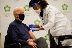 President-elect Joe Biden receives his first dose of the coronavirus vaccine at ChristianaCare Christiana Hospital in Newark, Del., Dec. 21, 2020, from nurse practitioner Tabe Mase.