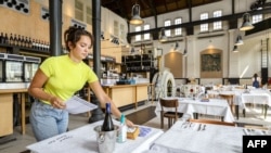 An employee prepares a cafe-restaurant for the reopening in Amsterdam, The Netherlands, on May 26, 2020, during the ongoing coronavirus pandemic (COVID-19).