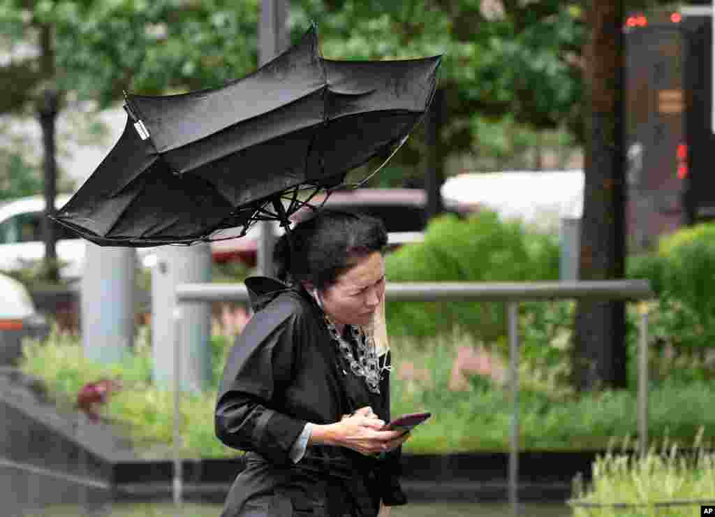 열대성 태풍 엘사가 미국 뉴욕시를 강타하면서 폭우가 내리는 가운데 거리의 시민이 쓰고 있는 우산이 강풍에 뒤집어 졌다. 