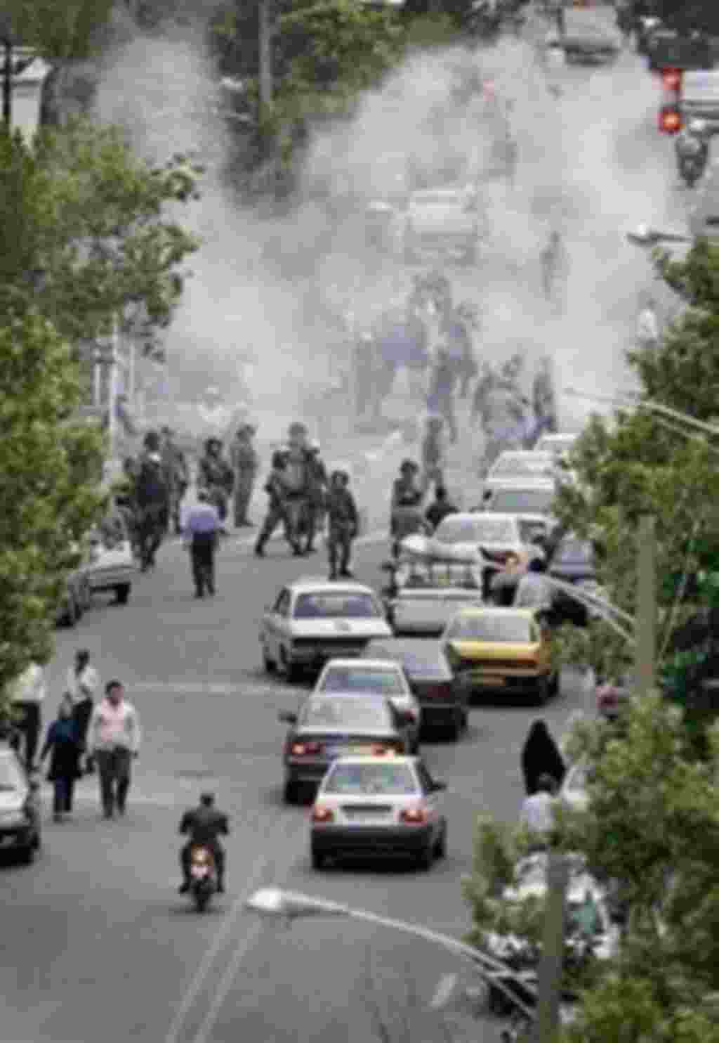 Iranian riot police stand in front of a cloud of tear gas as supporters of reformist candidate Mir Hossein Mousavi fight running battles using stones and petrol bombs against police, as they protesting the results of the Iranian presidential election in T