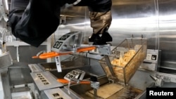 The Flippy 2 robot takes fries out of oil at a lab of manufacturer Miso Robotics Inc in Pasadena, California, on September 27, 2022, in this screen grab from a REUTERS video. (Sandra Stojanovic/REUTERS TV via REUTERS)