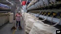 A worker sweeps loose cotton near a production line at the Wenzhou Tiancheng Textile Company, one of China's largest cotton recycling plants in Wenzhou in eastern China's Zhejiang province on March 20, 2024.