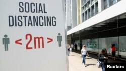 FILE PHOTO: A social distancing sign is seen in Oxford Street, as the outbreak of the coronavirus disease (COVID-19) continues, in London, Britain June 22, 2020. REUTERS/John Sibley/File Photo