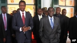 FILE - Zambian President Edgar Lungu (L) and Zimbabwean President Robert Mugabe are seen walking after a meeting at State House in Harare, Zimbabwe, Feb. 6, 2015.