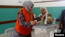 A Palestinian woman casts her ballot at a polling station during municipal elections in the northern West Bank town of Anabta, near Tulkarm, May 13, 2017.