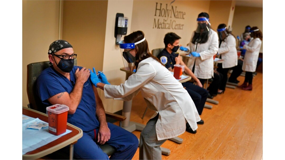 FILE - Staff members receive the COVID-19 vaccine at Holy Name Medical Center in Teaneck, N.J., Dec. 17, 2020.