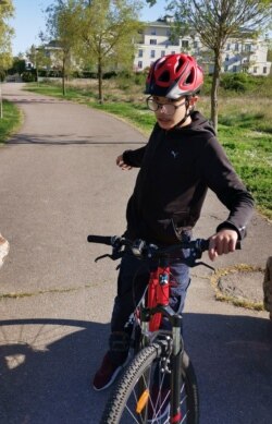 Mohammed, a 14-year-old with autism, on his bike outside his home April 15, 2020, in Mantes-la-Jolie, west of Paris.