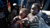 A girl holds a young child shortly after arriving at a U.N. camp for the displaced in the Unity state capital of Bentiu in June 2015. More than 2 million people have been displaced by 20 months of fighting. 