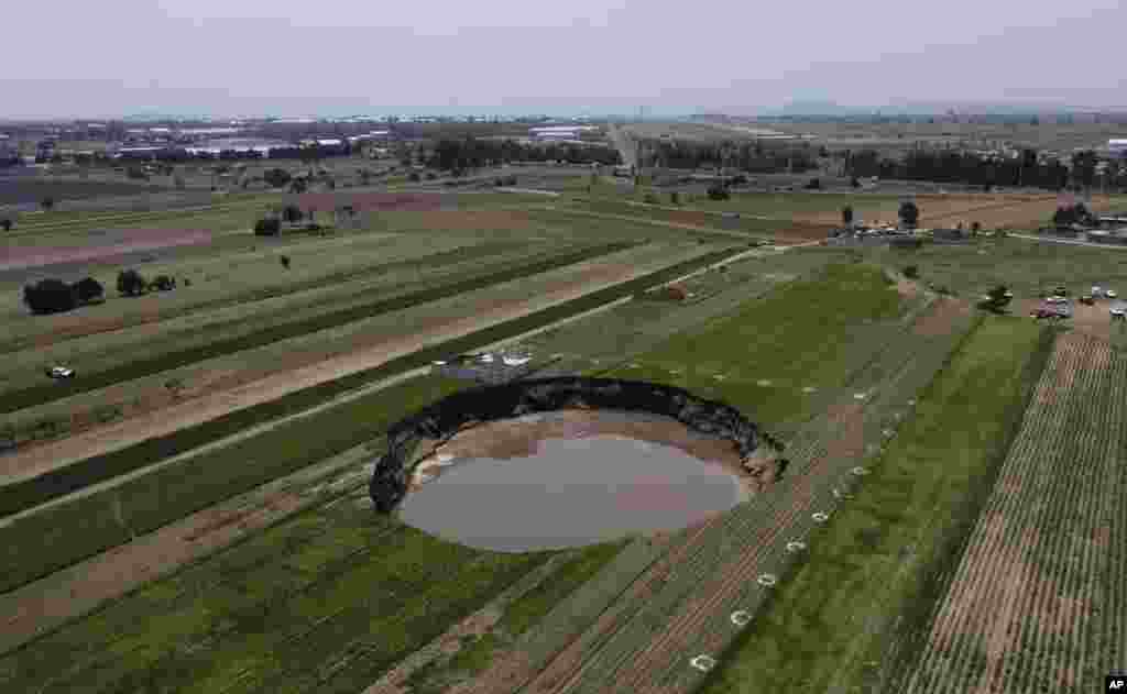 A water-filled sinkhole grows on a farming field in Zacatapec, on the outskirts of Puebla, Mexico.