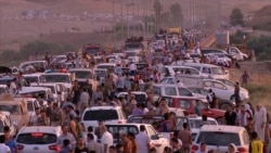 FILE - Iraqi people from the Yazidi community arrive in Irbil in northern Iraq after Islamic militants attacked the towns of Sinjar and Zunmar, in this image made from video taken Aug. 3, 2014.