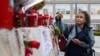 A woman places a rosary at the statue of late Pope John Paul II and Gemelli Hospital, where Pope Francis is admitted for ongoing pneumonia treatment, in Rome, Italy, March 12, 2025.