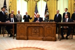 FILE - President Donald Trump (C), Serbian President Aleksandar Vucic (L) and Kosovo Prime Minister Avdullah Hoti (R) listen as U.S. Vice President Mike Pence speaks during a signing ceremony in the White House in Washington, Sept. 4, 2020.