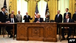 U.S. President Donald Trump (C), Serbian President Aleksandar Vucic (L) and Kosovo Prime Minister Avdullah Hoti (R) listen as U.S. Vice President Mike Pence speaks during a signing ceremony in the White House in Washington, Sept. 4, 2020.