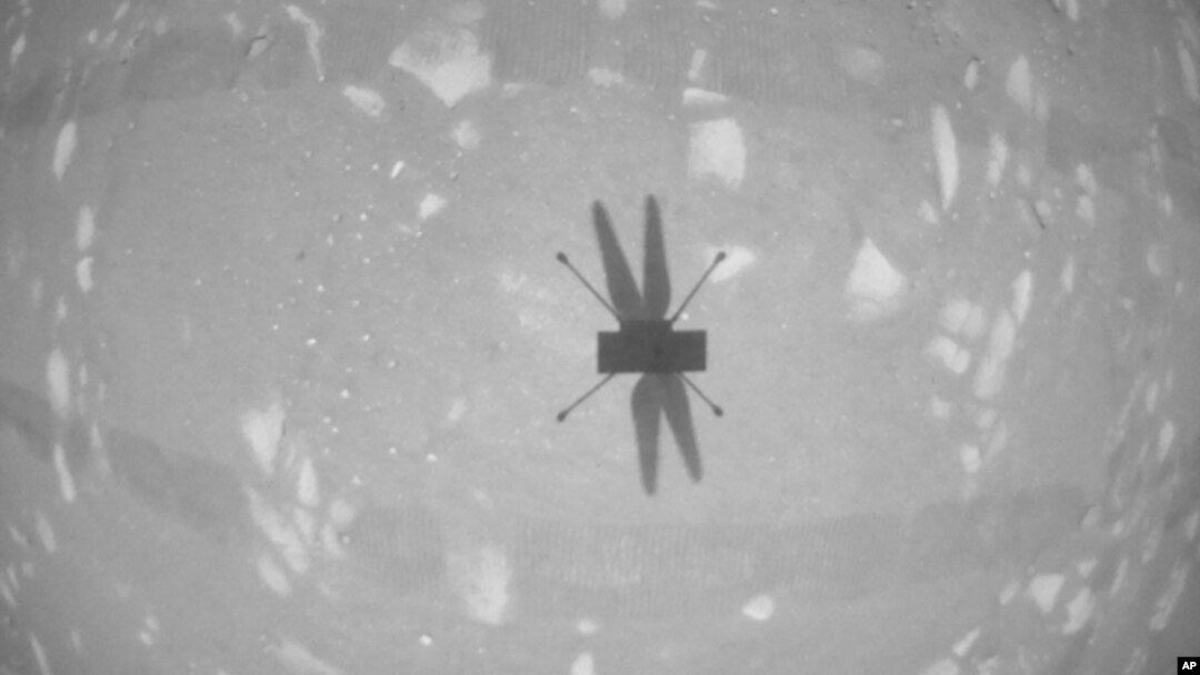 En esta foto de archivo del 22 de abril de 2021, puesta a disposición por la NASA, el helicóptero Ingenuity Mars fotografía su sombra con su cámara de navegación en blanco y negro durante su segundo vuelo.