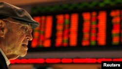 FILE - A Brazilian investor looks at the stock price monitors at the BM&FBOVESPA Stock Market in Sao Paulo, Aug. 10, 2011. 