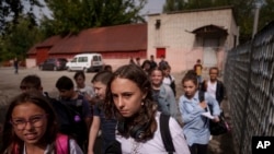 Anak-anak bergerak menuju basemen gedung sekolah mereka saat peringatan bahaya dibunyikan di Zaporizhzhia, Ukraina, pada 3 September 2024. (Foto: AP/Evgeniy Maloletka)