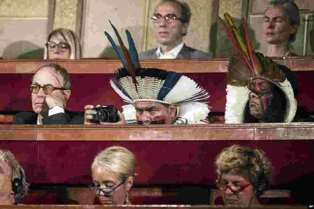 Delegates, some in traditional dress, attend the opening of the Consciousness Summit in Paris, France.