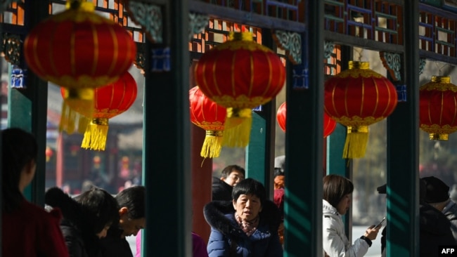 FILE -People rest under decorative lanterns at the Lunar New Year of the Dragon celebration in Beijing on Feb. 13, 2024. A report says the videos promoting Chinese culture are prominent on China's Spanish-language YouTube channels.