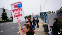 Catherine Minnick, an electrician who has worked for Boeing for six years, works the picket line with fellow union members after they voted to reject a contract offer and strike, Sept. 15, 2024, near the company's factory in Everett, Wash.