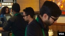 Two Starbucks employees work to fill orders at the chain coffee shop in Falls Church, Virginia, May 18, 2016. (VOA/Catherine Maddux)