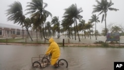 Seseorang mengendarai sepedanya melalui jalan yang banjir di tengah hujan saat Badai Milton melewati pantai Progreso, negara bagian Yucatan, Meksiko, Selasa, 8 Oktober 2024.