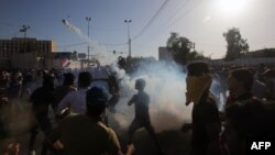 A supporter of Iraqi cleric Moqtada al-Sadr hurls a tear gas canister back at security forces during clashes after demonstrators broke into Baghdad's fortified "Green Zone" in Baghdad, Iraq, on May 20, 2016. 