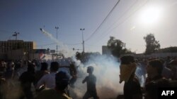 A supporter of Iraqi cleric Moqtada al-Sadr hurls a tear gas canister back at security forces during clashes after demonstrators broke into Baghdad's fortified "Green Zone" in Baghdad, Iraq, on May 20, 2016. 