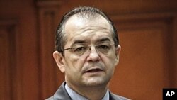 Romanian Premier Emil Boc looks at lawmakers before a no-confidence vote in Bucharest, Romania. Premier Emil Boc announced the immediate resignation of himself and his government on Monday, February 6, 2012, saying he wanted to protect the stability of th