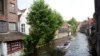 FILE - Tourists ride in a boat down a main canal in Bruges, Belgium, May 26, 2016. Tourism has dropped in Belgium since the deadly bombings in March.