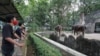 Para pengunjung mengenakan masker sambil mengamati gajah di hari pertama pembukaan kembali Kebun Binatang Ragunan di tengah pandemi virus corona (Covid-19) di Jakarta, 20 Juni 2020. (Foto: Reuters)