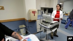 Dr. Melisa Lai-Becker goes over test results with a patient at CHA Everett Hospital in Everett, Mass., May 8, 2018.