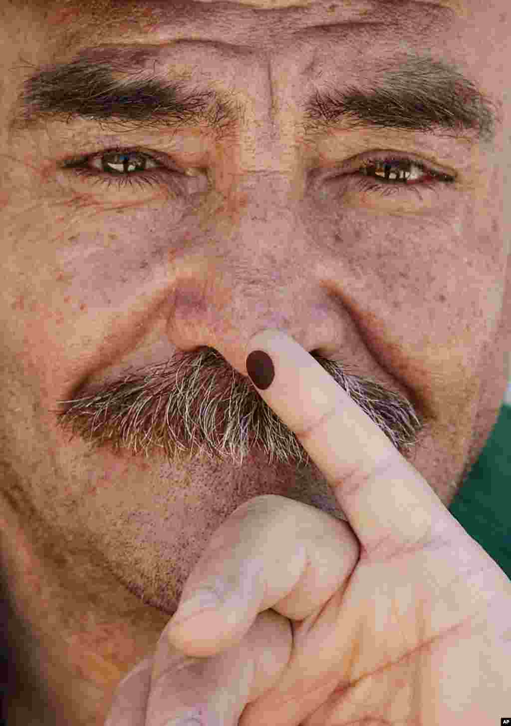 A Syrian man displays a stained finger after voting in a parliamentary election at a polling station in Damascus. (Reuters)