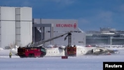 Prevrnuti avion na aerodromu u Torontu (Foto: REUTERS/Arlyn McAdorey)