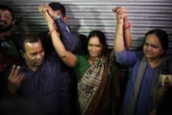 Badrinath, left, Asha Devi, center, parents of the victim of the fatal 2012 gang rape on a moving bus, hold hands after the rapists of their daughter were hanged, in New Delhi, India, March 20, 2020.