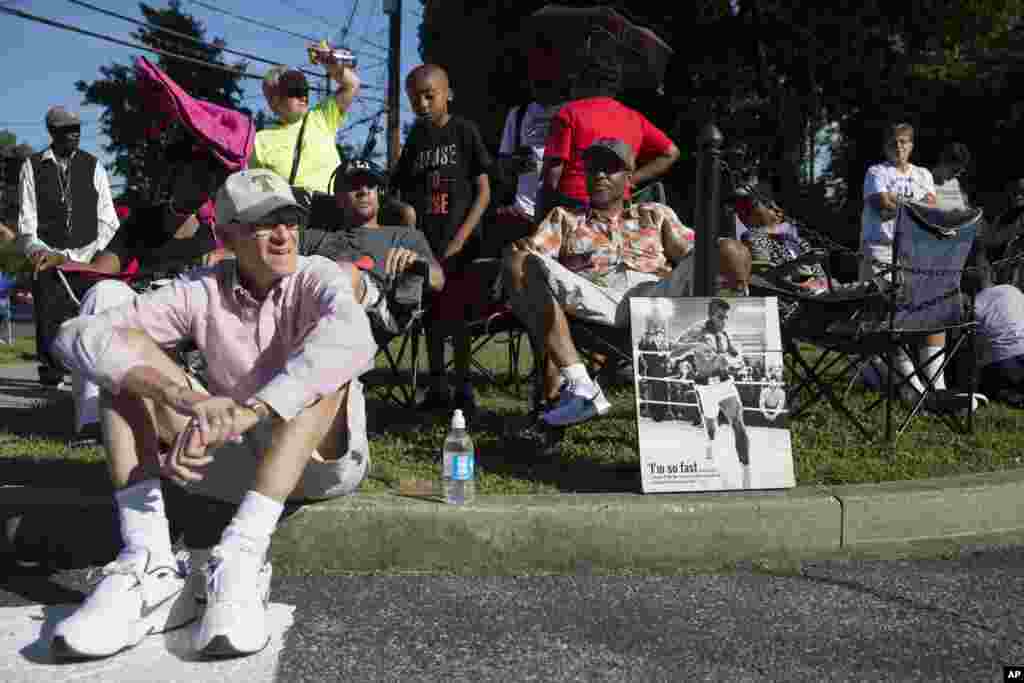 Orang-orang menunggu iring-iringan yang membawa jenazah Muhammad Ali memasuki Cave Hill Cemetery, Louisville, Kentucky, 10 Juni 2016.