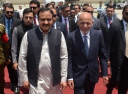 In this photo released by the Press Information Department, visiting Afghan President Ashraf Ghani, right, is received by the chief minister of Punjab province Usman Buzdar at Lahore airport in Pakistan, June 28, 2019.