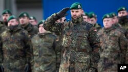 FILE - German Bundeswehr soldiers of the 12th Mechanized Infantry Brigade, 122nd Infantry Battalion, take part in a NATO enhanced forward presence battalion welcome ceremony at the Rukla military base 130 km (80 miles) west of Vilnius, Lithuania, Feb. 7, 2017.