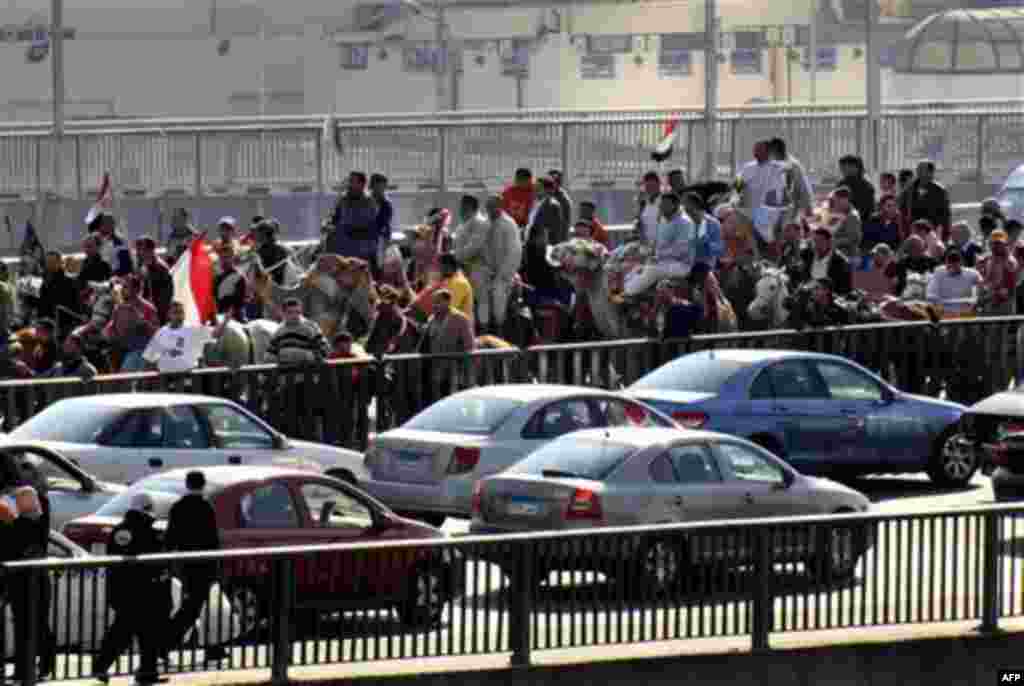 Supporters of President Hosni Mubarak, including some riding horses and camels and wielding whips, march towards anti-Mubarak protesters in Cairo, Egypt, Wednesday, Feb.2, 2011. Several thousand supporters of President Hosni Mubarak clashed with anti-gove