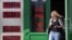 RUSSIA -- A woman leaves exchange office with an electronic panel displaying currency exchange rates for the U.S. dollar and the euro against the Russian ruble in Moscow, August 23, 2018.