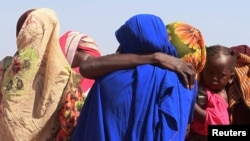 FILE - Women from El Geneina, West Darfur, weep after receiving news of their missing relatives in Ardamata, as they waited for them in Adre, Chad, November 7, 2023