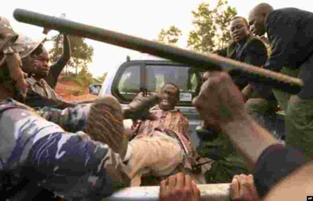 Uganda's security agents scuffle with Forum for Democratic Change (FDC) leader Kizza Besigye (C) at the Kasangati suburb of the capital Kampala, April 18, 2011. Ugandan opposition leader Besigye was arrested on Monday during a protest against high food an