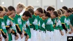 Santa Fe High School baseball players bow their heads in a moment of silence for the shooting victims at their school before a baseball game against Kingwood Park High School in Deer Park, Texas, May 19, 2018. Another moment of silence was observed Monday throughout Texas.