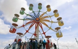 Revelers gather for funfair after Eid prayers, amid the COVID-19 pandemic, on the first day of Eid al-Fitr, at the Darasalam garden in Mogadishu, Somalia, May 13, 2021.