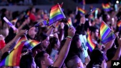 Fans waive rainbow flags in honor of LGBT Pride month in Los Angeles, June 2, 2018.