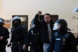 Spanish rapper Pablo Hasel reacts as he is detained by riot police inside the University of Lleida, after he was sentenced to jail time on charges including insulting the monarchy and glorifying terrorism, in Lleida, Spain, Feb. 16, 2021.