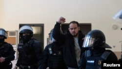 Spanish rapper Pablo Hasel reacts as he is detained by riot police inside the University of Lleida, after he was sentenced to jail time on charges including insulting the monarchy and glorifying terrorism, in Lleida, Spain, Feb. 16, 2021. 